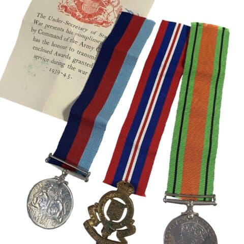 Second World War Defence Medal and War Medal either side of a Royal Army Ordnance Corps cap badge, with the original War Office letter