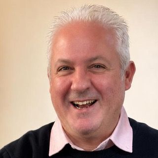 Ricci, watch specialist, laughing at a valuation table